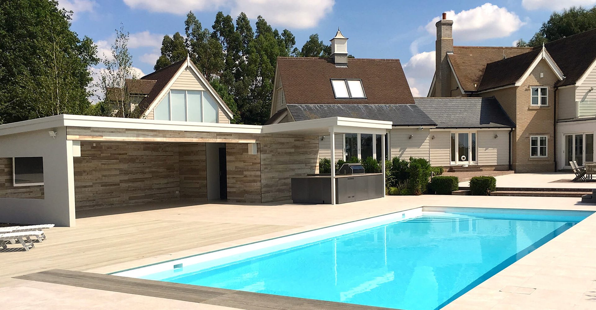Rear view of swimming pool and pool house construction